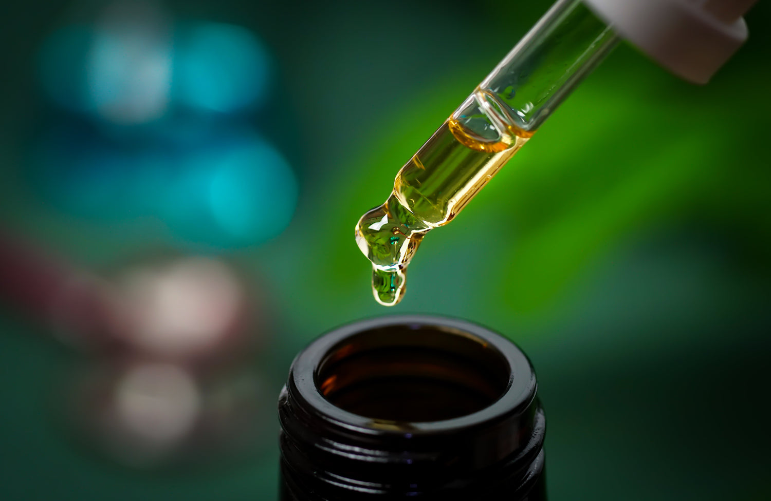 CBD-Hanföl, eine Hand hält einen Tropfen Cannabisöl vor einem unscharfen Becherglas-Hintergrund. Alternative Medizin. Tropfendosierung eines biologischen und ökologischen Hanfpflanzen-Arzneimittels (CBD-Öl).