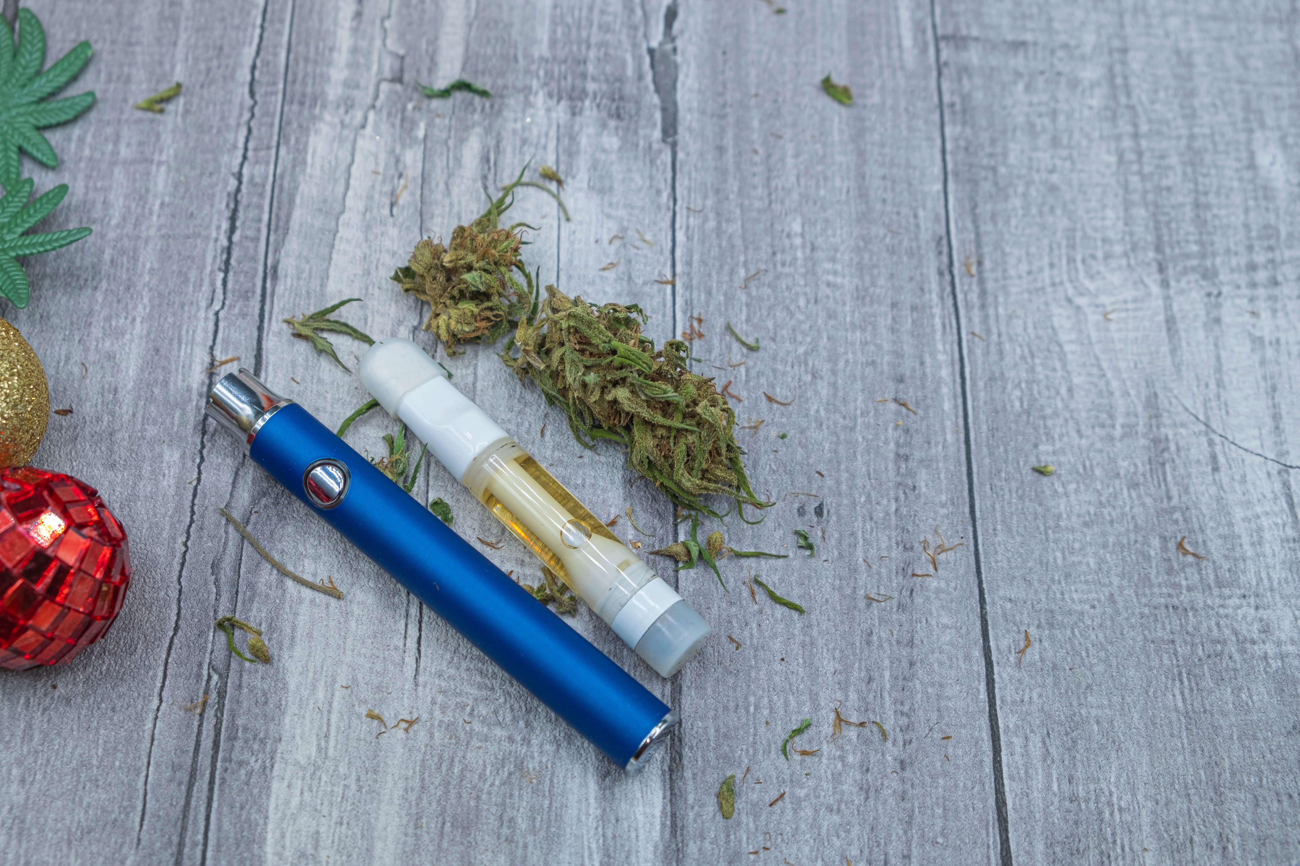Cannabisölextrakt in einer Vape-Pen-Karteusche und Cannabisblüten
