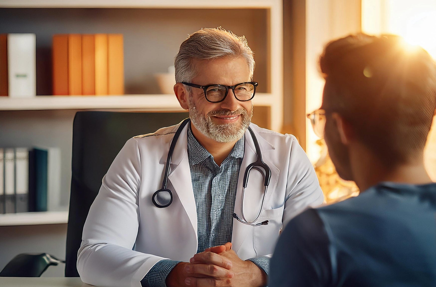 Ein Arzt spricht mit einem Patienten in einem Untersuchungsraum, um medizinische Informationen auszutauschen.